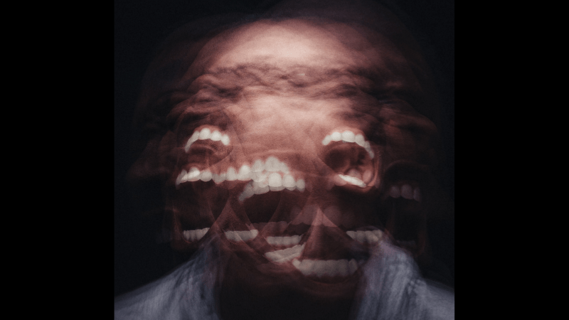 human being so angry that the face is photographically distorted with open screaming mouth with teeth everywhere