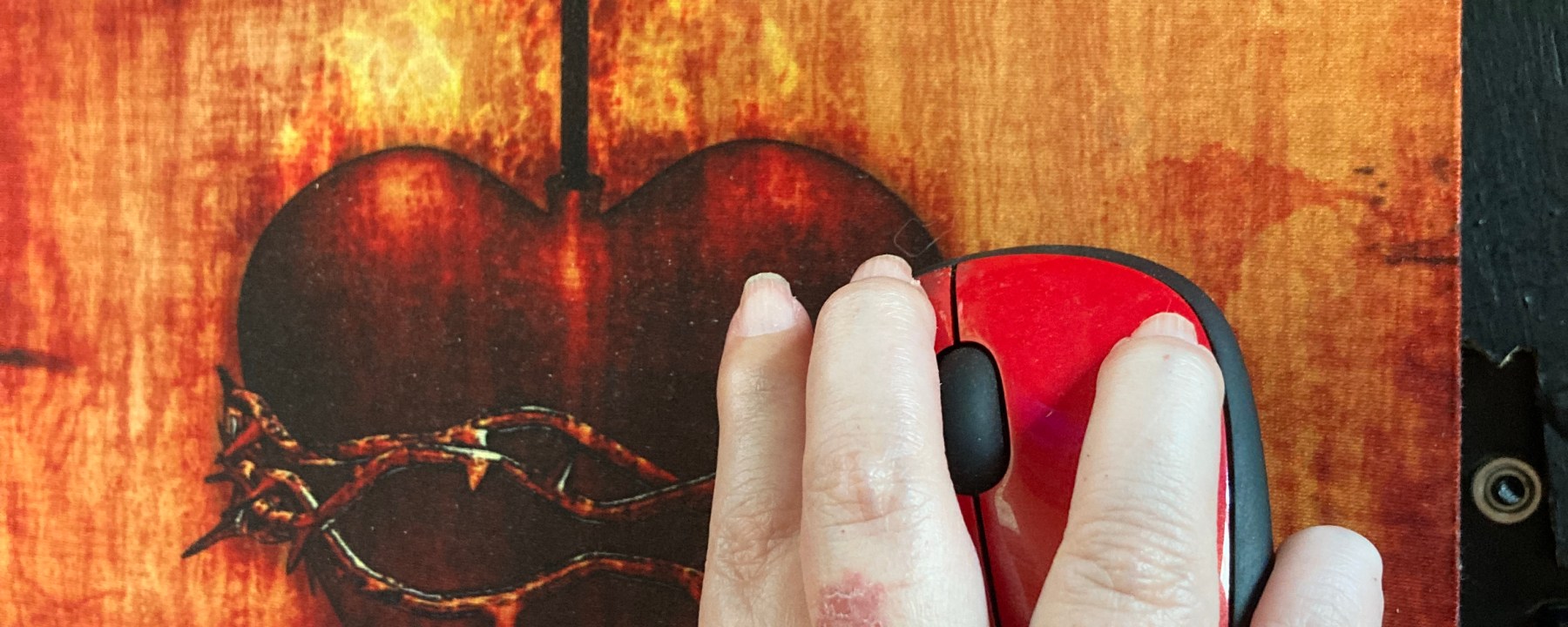 Sacred Heart of Jesus mousepad and a disabled woman holding a computer mouse