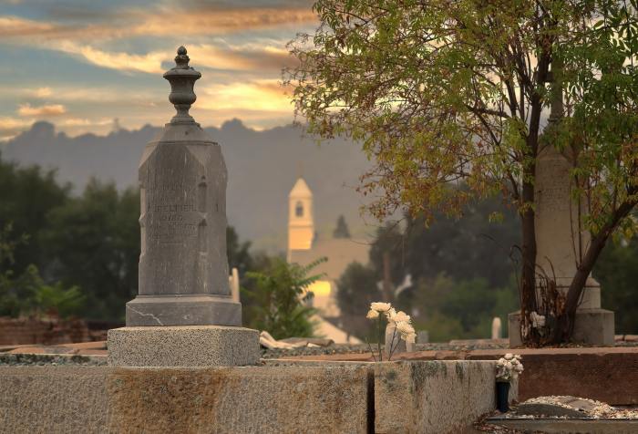 Graveyard with a church in the background and a sky that looks like heaven