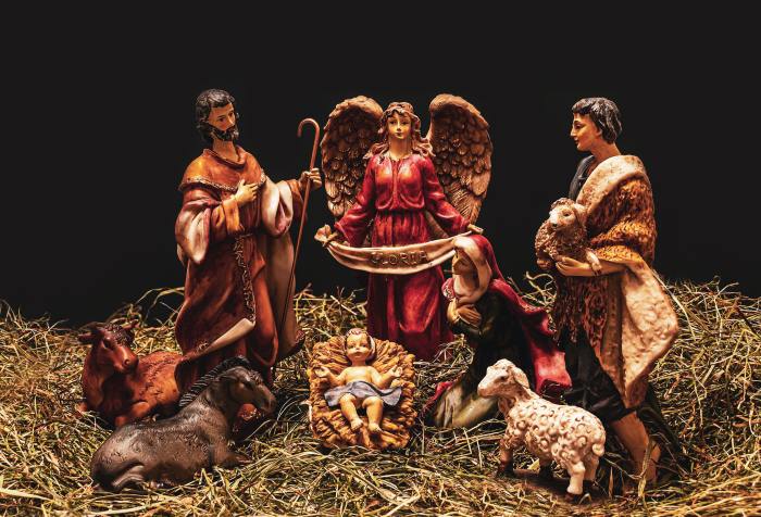 A Christmas manger scene with baby Jesus, Mary, Joseph, shepherds, and an angel