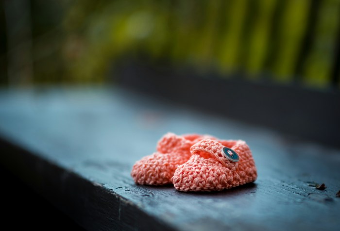 Pink baby booties on a park bench